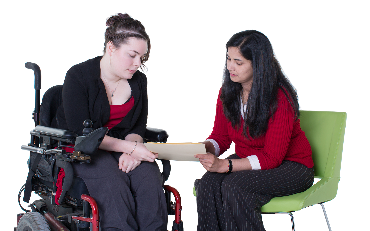 2 people looing at a document together. One person is in a wheelchair.