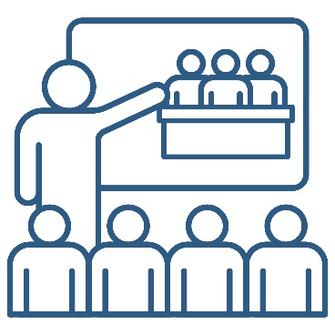 A person presenting to a group of people. They are pointing to a white board that shows a Quality Assurance Panel.