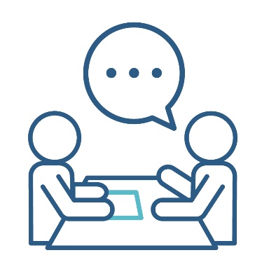 Two people talking around a table.