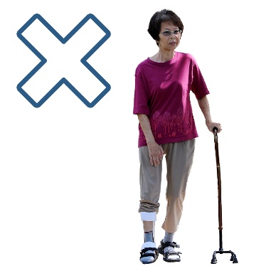 A cross next to a person with a leg brace and using a walking stick.