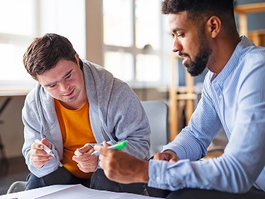 2 people working together on a document.