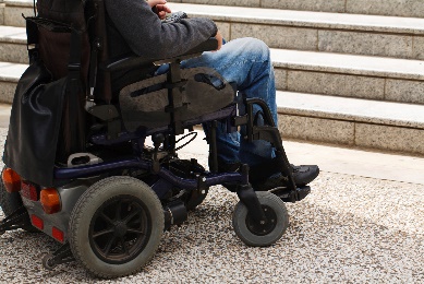 A person in a wheelchair in front of some stairs.