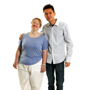 A person with disability being supported by someone. They both have a happy expression.